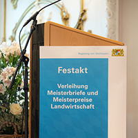 Rednerpult und Plakat mit Schrift: Festakt, Verleihung Meisterbriefe und Meisterpreise Landwirtschaft